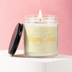 Burning candle in a jar with lid off, showing "Smells like Happy Tears" text.
