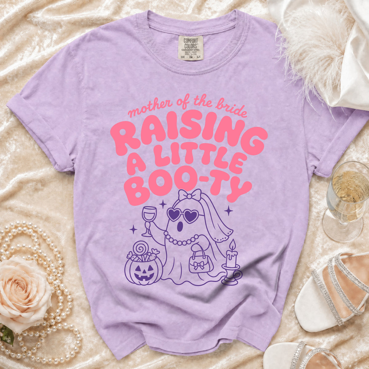 Purple Comfort Colors t-shirt with "mother of the bride raising a little boo-ty" and ghost graphic.