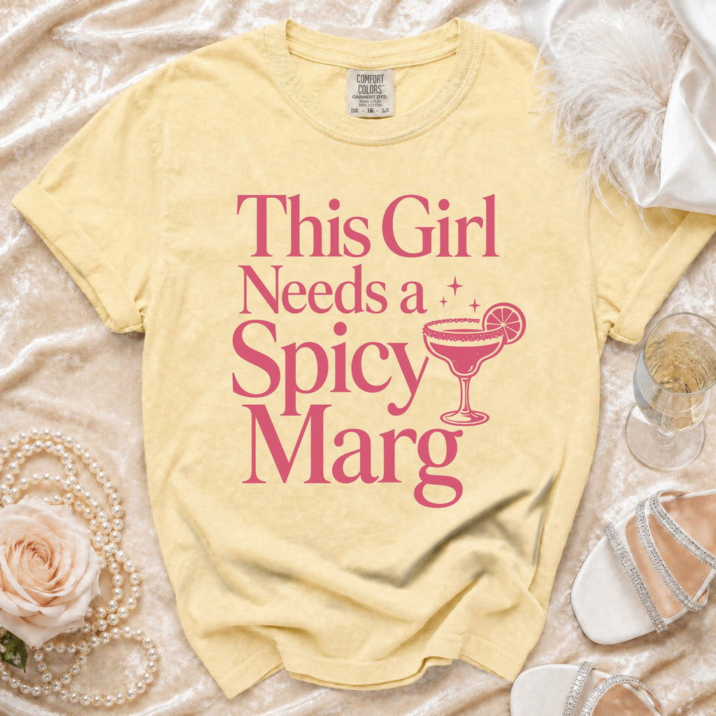 Light yellow t-shirt with pink text "This Girl Needs a Spicy Marg" and margarita graphic.