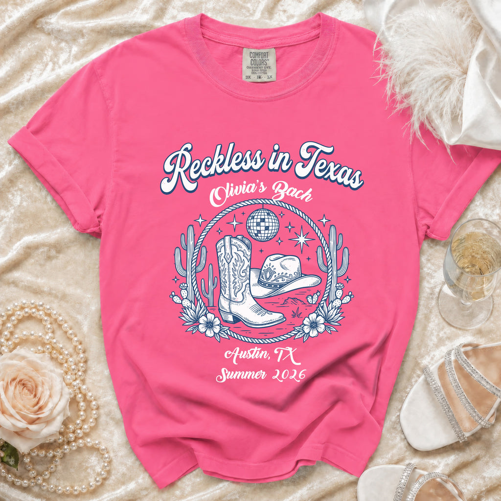 Pink t-shirt with "Reckless in Texas Olivia's Bach Austin, TX Summer 2026" text.