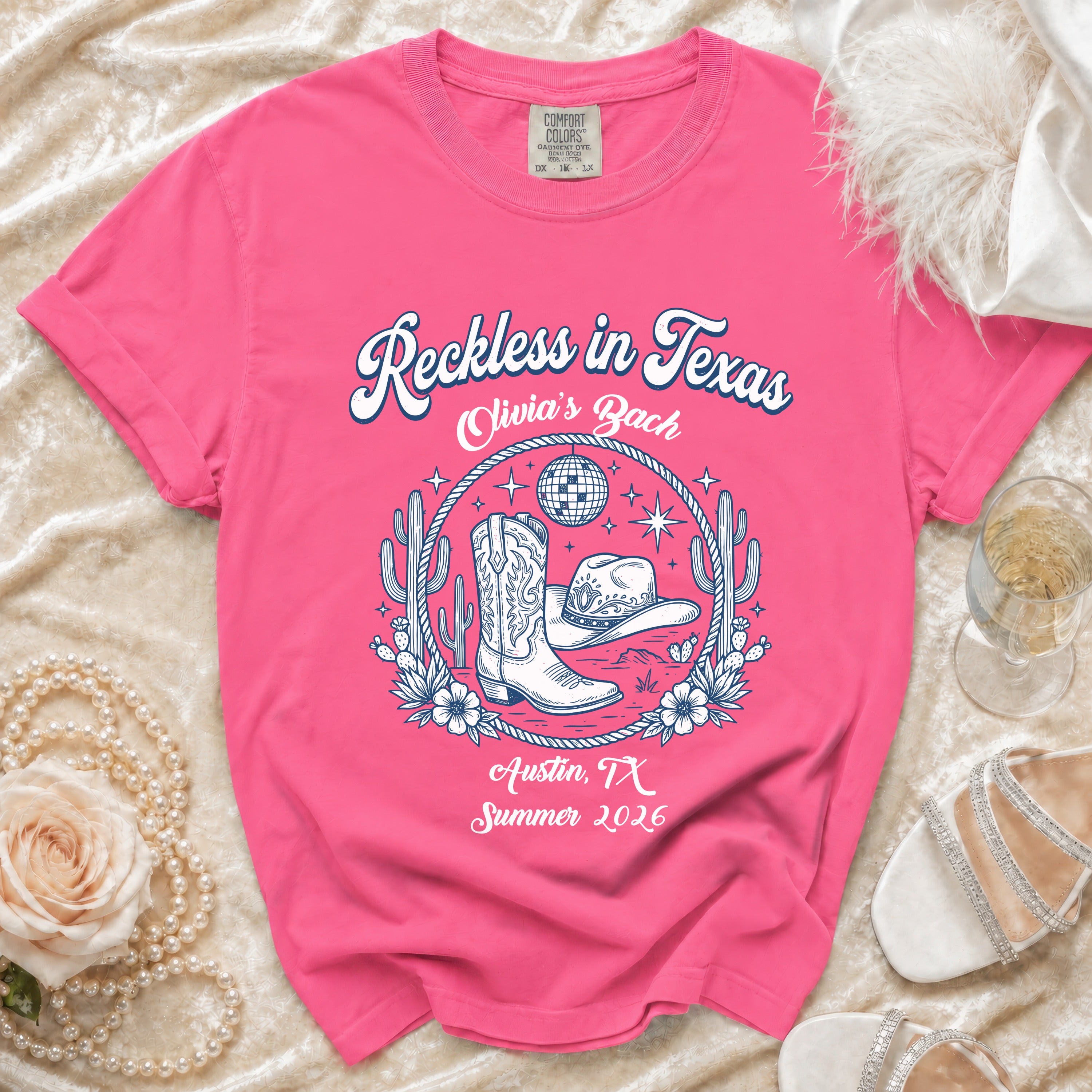 Pink t-shirt with "Reckless in Texas Olivia's Bach Austin, TX Summer 2026" text.
