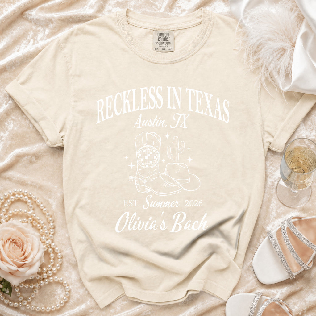 Cream t-shirt with "Reckless in Texas" and "Olivia's Bach" text.