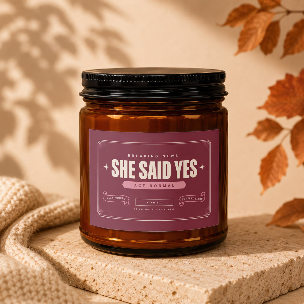 Amber glass candle with "She Said Yes" label, "Act Normal" and "Vowed" text.