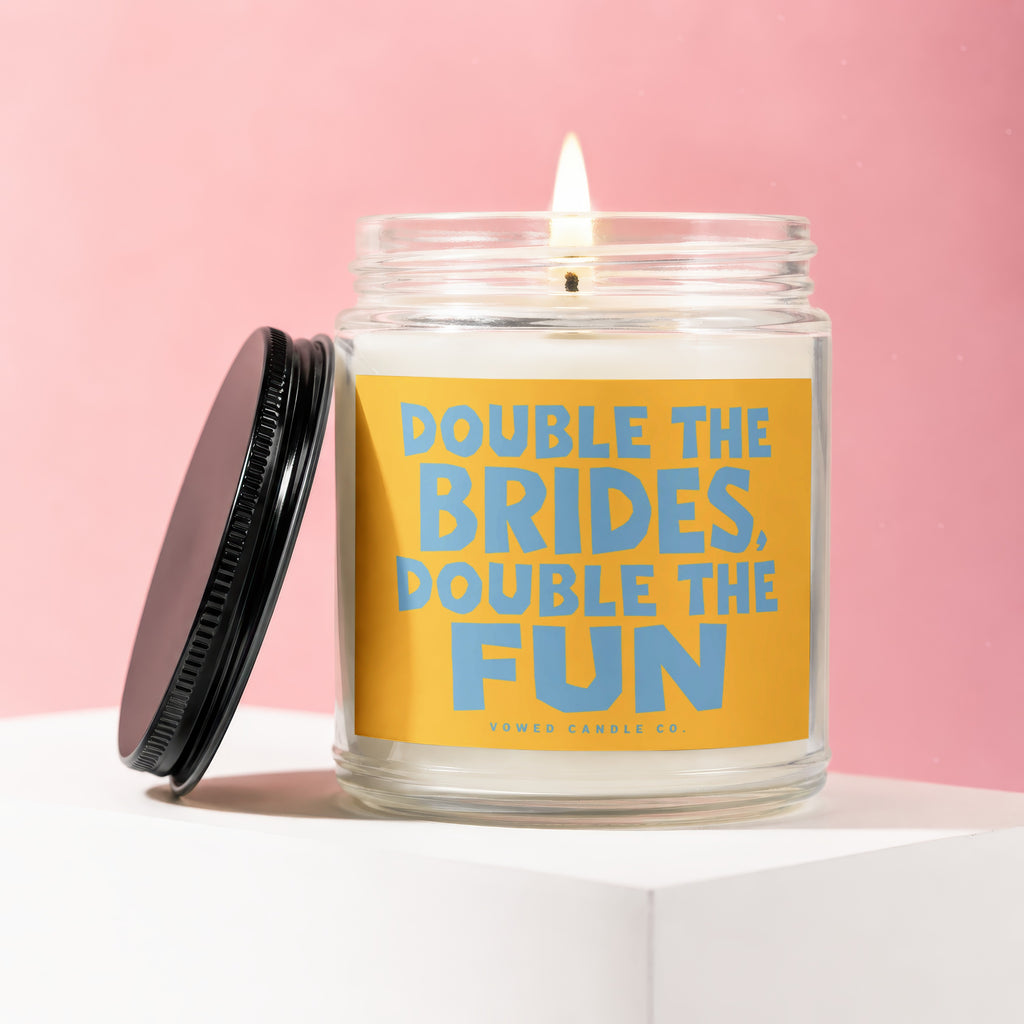Candle with orange label that reads "Double the Brides, Double the Fun."