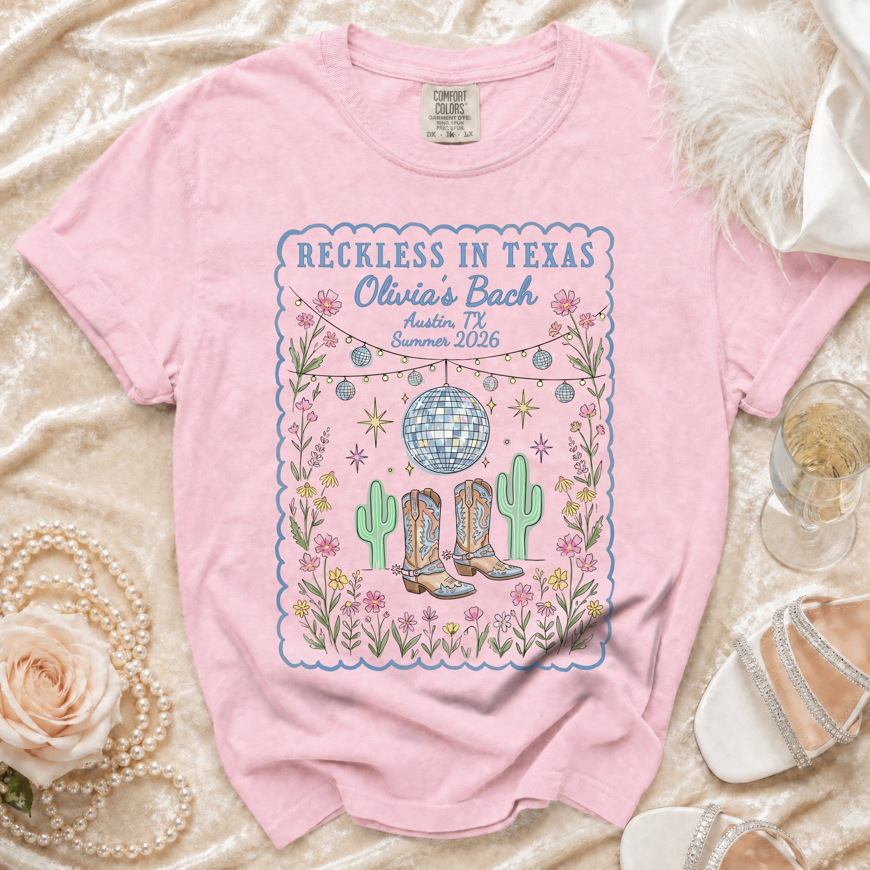 Pink t-shirt with "Reckless in Texas Olivia's Bach Austin, TX Summer 2026" design.