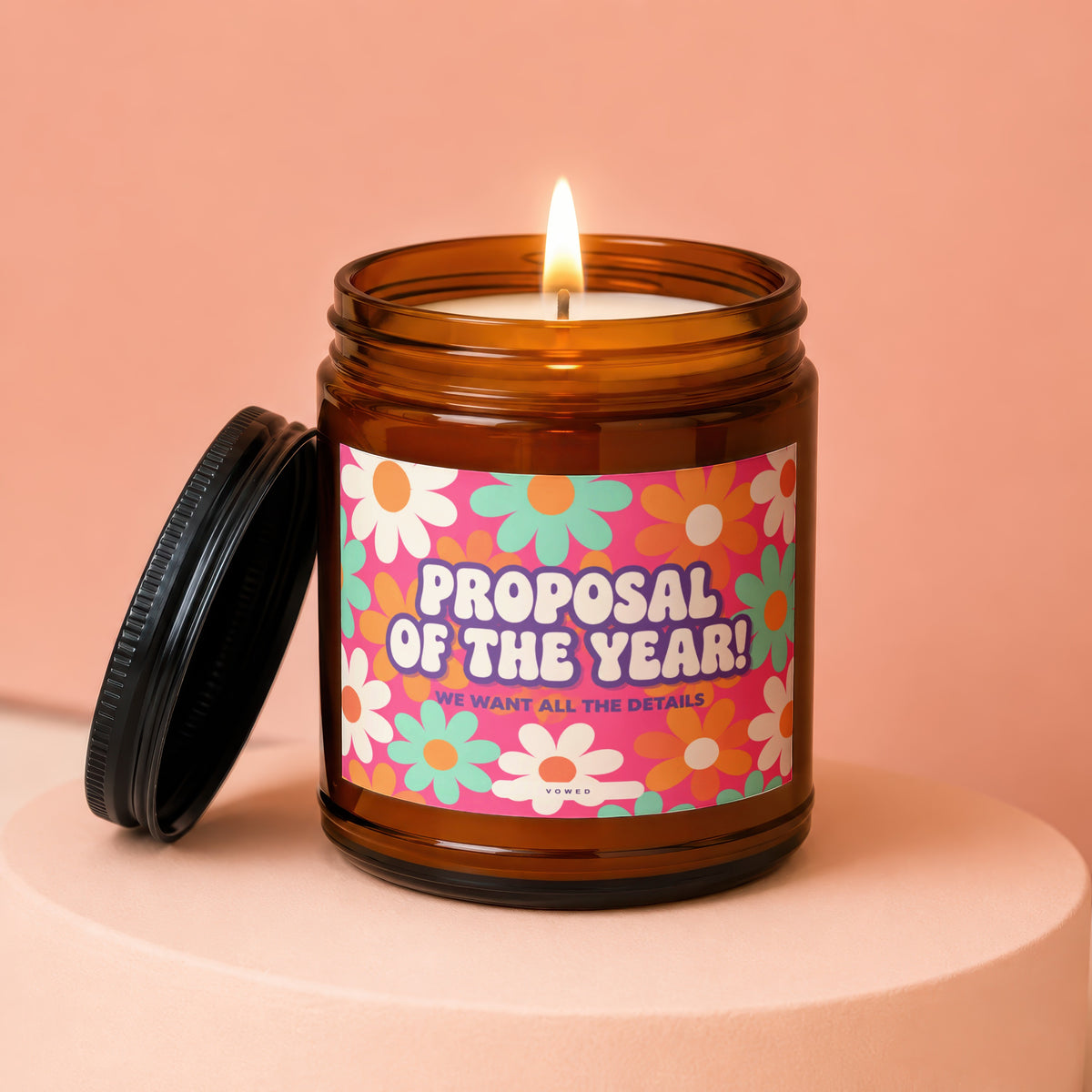 Amber jar candle with "Proposal Of The Year! We Want All The Details" text.