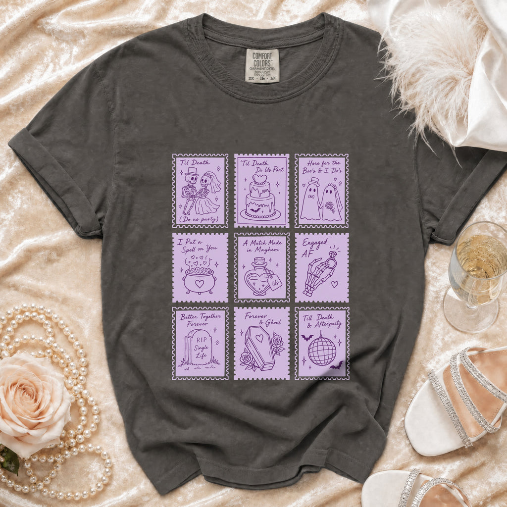 Dark gray t-shirt with purple stamp-like graphics of skeletons, ghosts, and wedding themes.