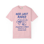 Pink t-shirt with "HER LAST RODEO" graphic, cowboy hat, rope, and boots.