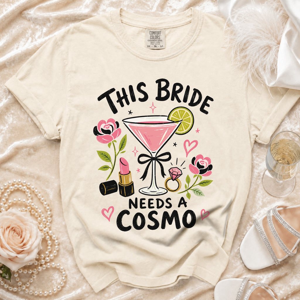 T-shirt with "This Bride Needs a Cosmo" text, martini, lipstick, and ring graphic.