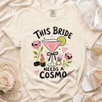 T-shirt with "This Bride Needs a Cosmo" text, martini, lipstick, and ring graphic.