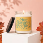Candle with lit wick and yellow label that reads "Our Favorite Plot Twist vowed".