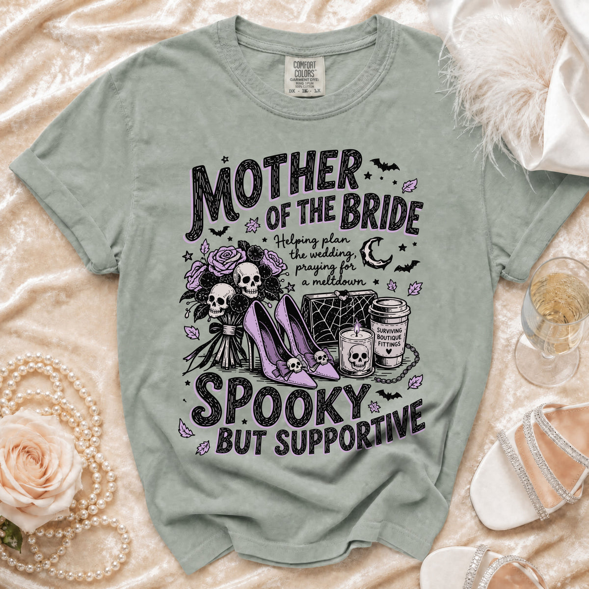T-shirt with "Mother of the Bride Spooky But Supportive" text and gothic illustrations.