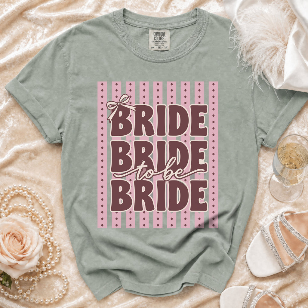 Green t-shirt with "Bride to be Bride" text and pink stripe background.