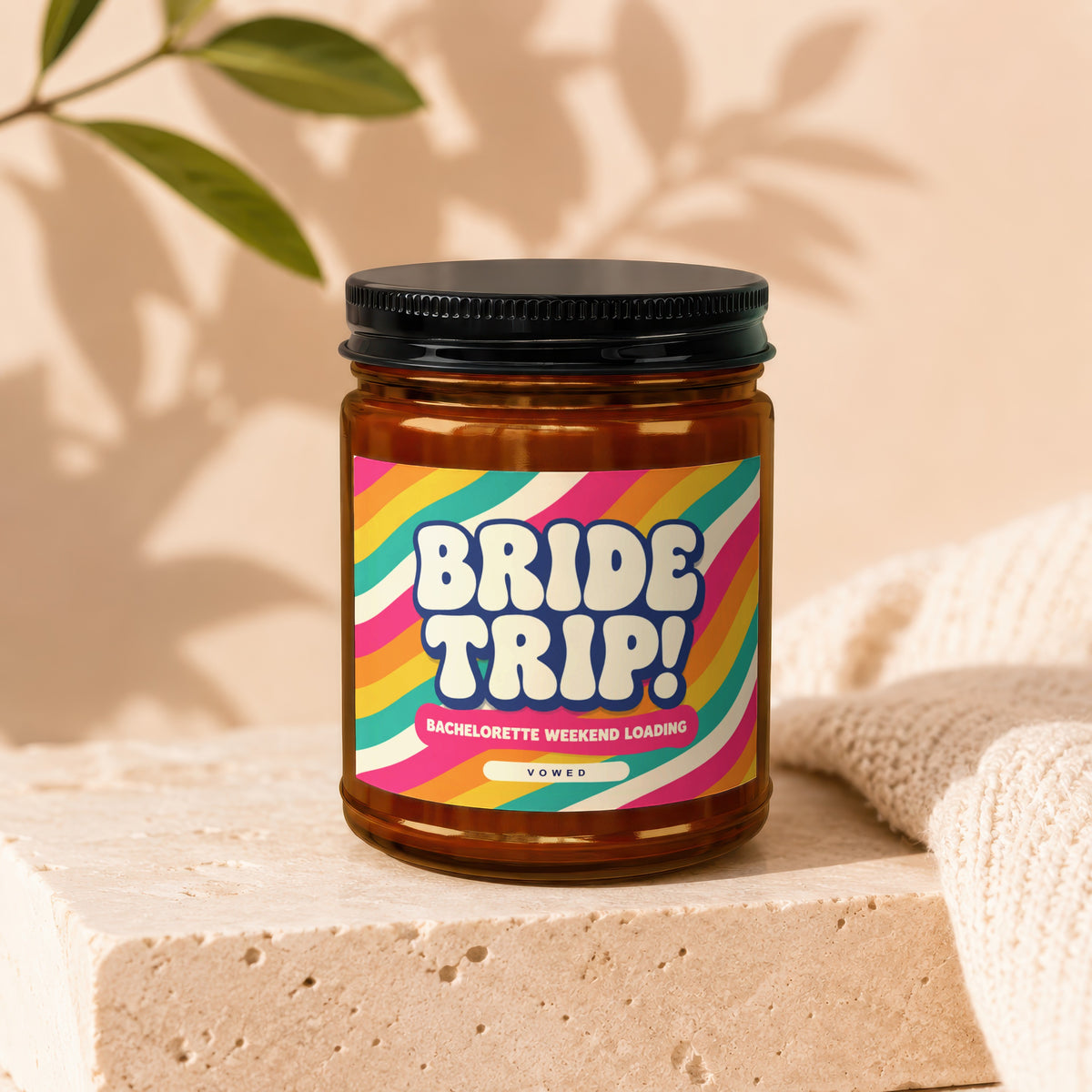 Amber candle jar with a "BRIDE TRIP! BACHELORETTE WEEKEND LOADING" label, Vowed.