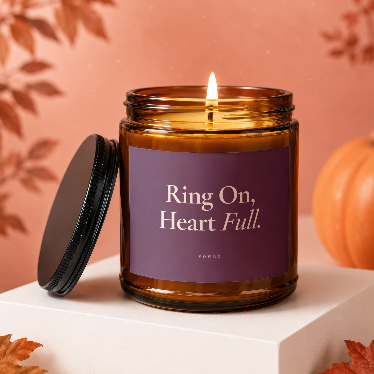 Amber jar candle with lit flame, purple label reads "Ring On, Heart Full."