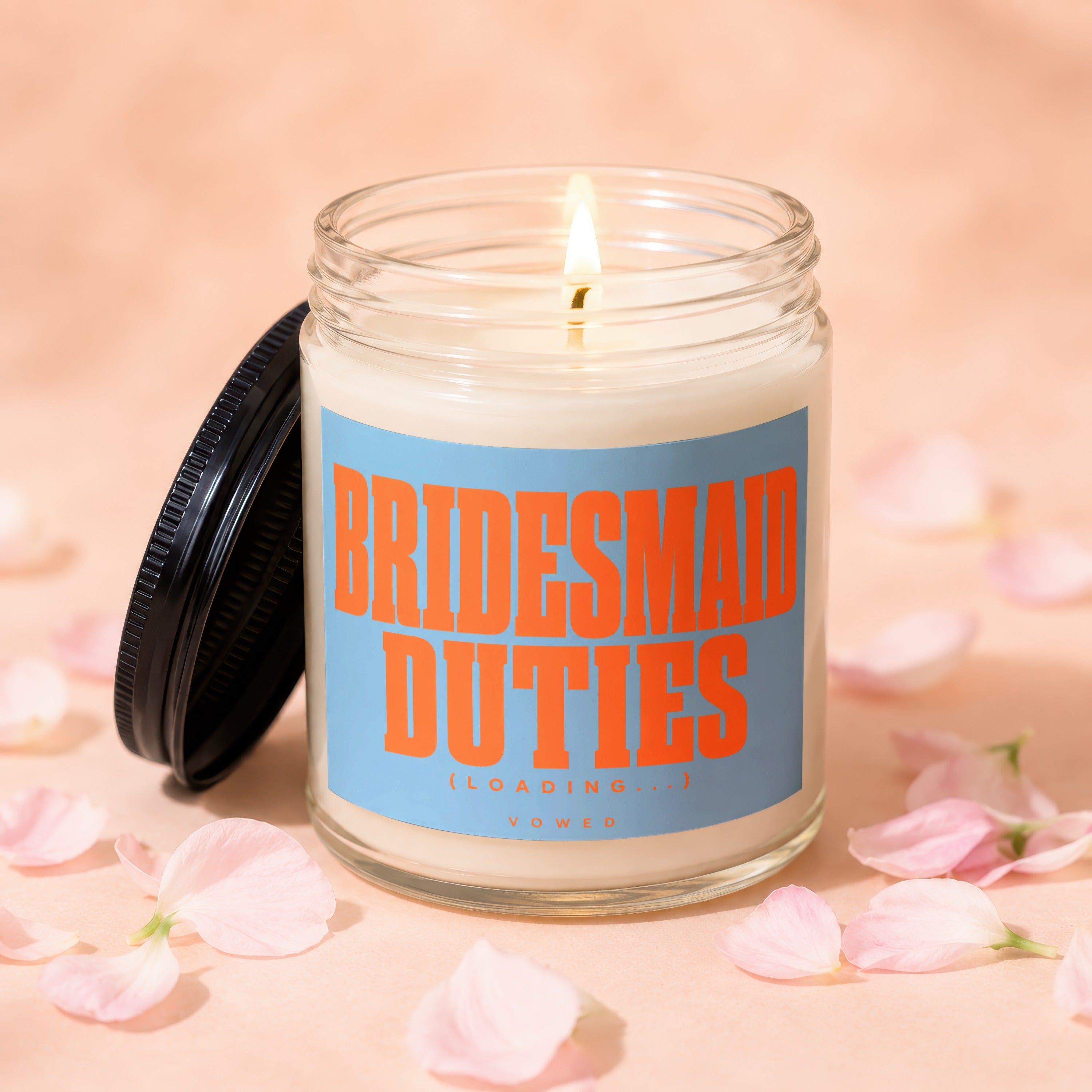 Candle with "BRIDESMAID DUTIES (LOADING...)" text, on a light peach background with petals.