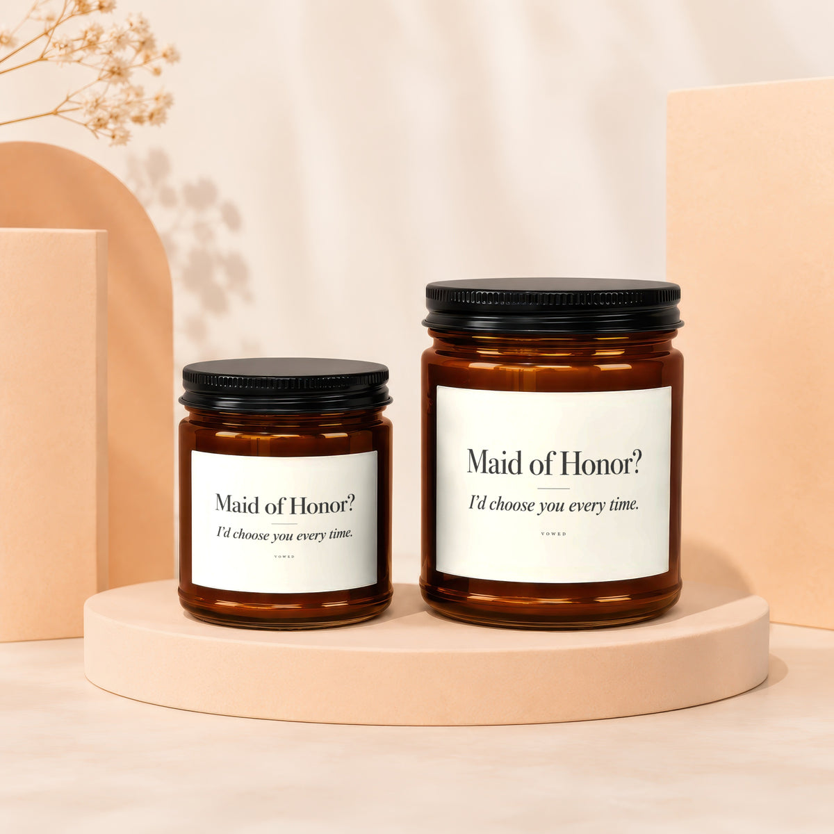 Two amber glass candles with white labels that read "Maid of Honor? I'd choose you every time."