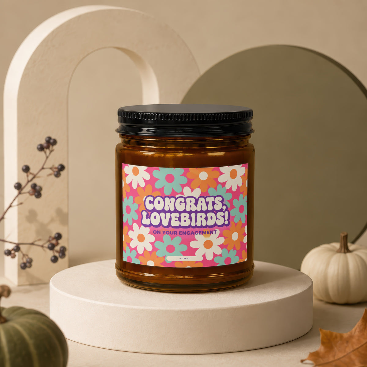 Amber jar candle with floral label reading "Congrats, Lovebirds! On Your Engagement".