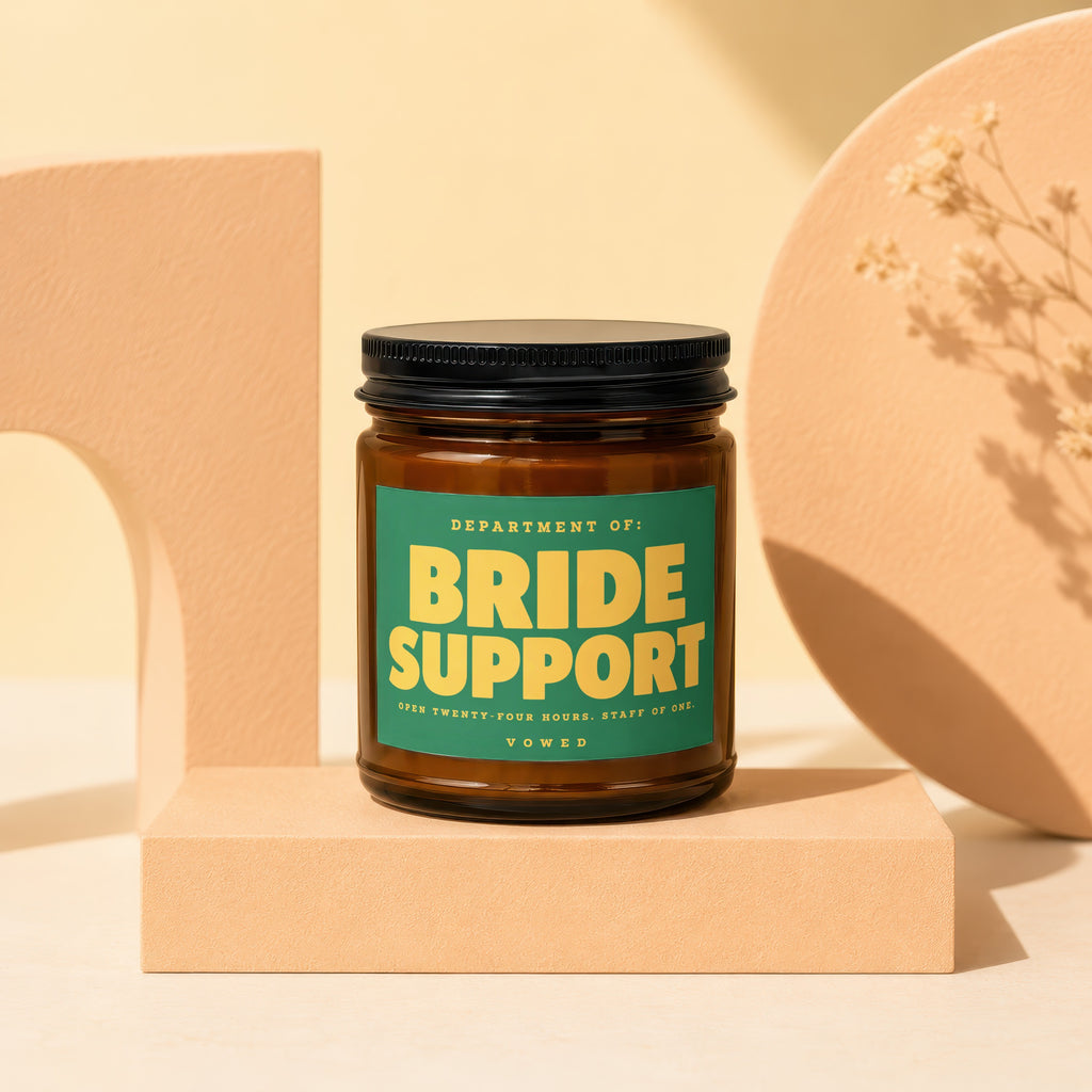 Brown glass candle labeled "BRIDE SUPPORT" with green and yellow text.