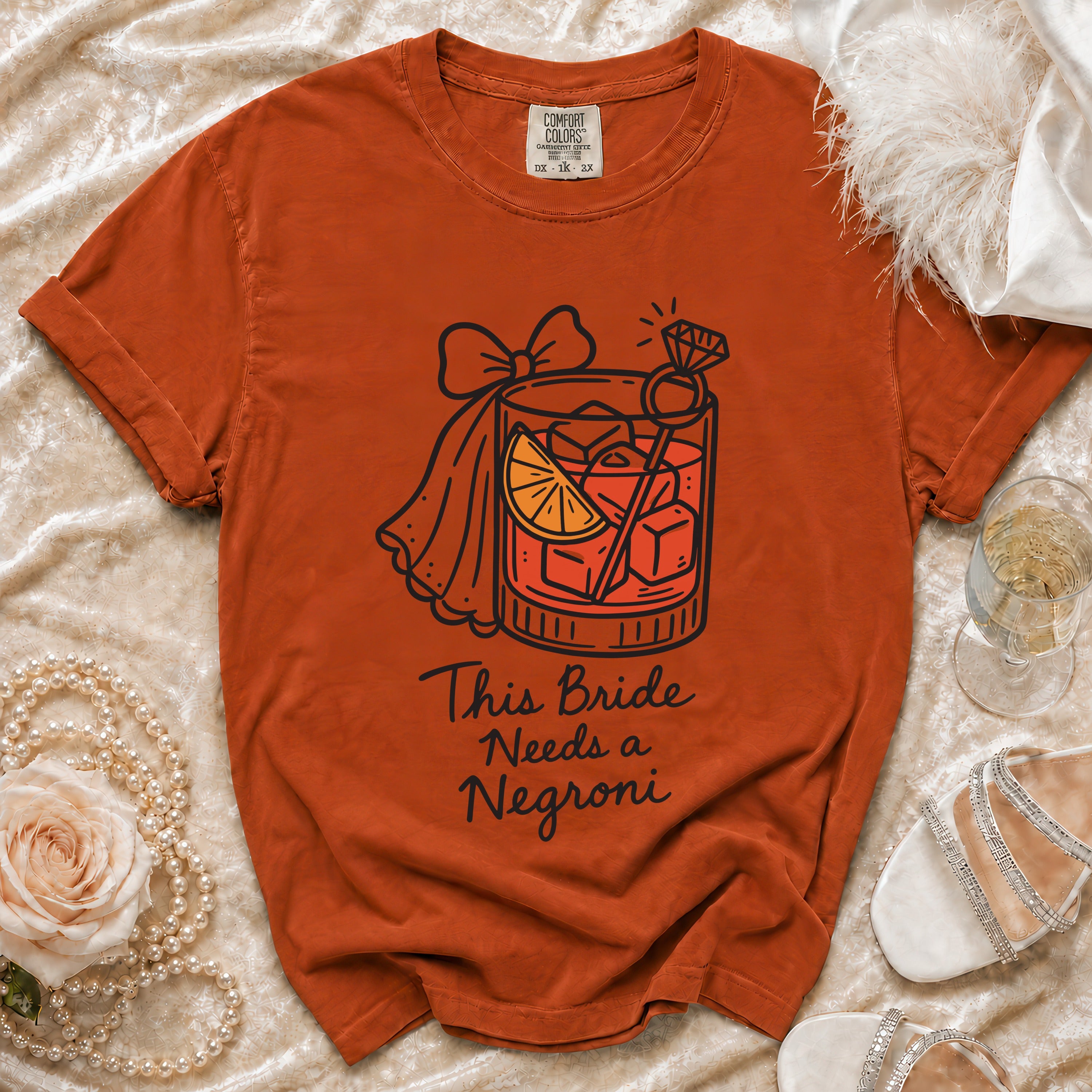 Orange t-shirt with "This Bride Needs a Negroni" graphic and cocktail imagery.