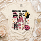 Light tan t-shirt with "Mother of the Bride Raising Hell Before I Do" Halloween graphic.