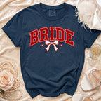 Navy t-shirt with red "BRIDE" text and white bow graphic.