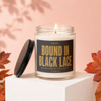 Glass candle labeled "Bound in Black Lace" with lid beside it.