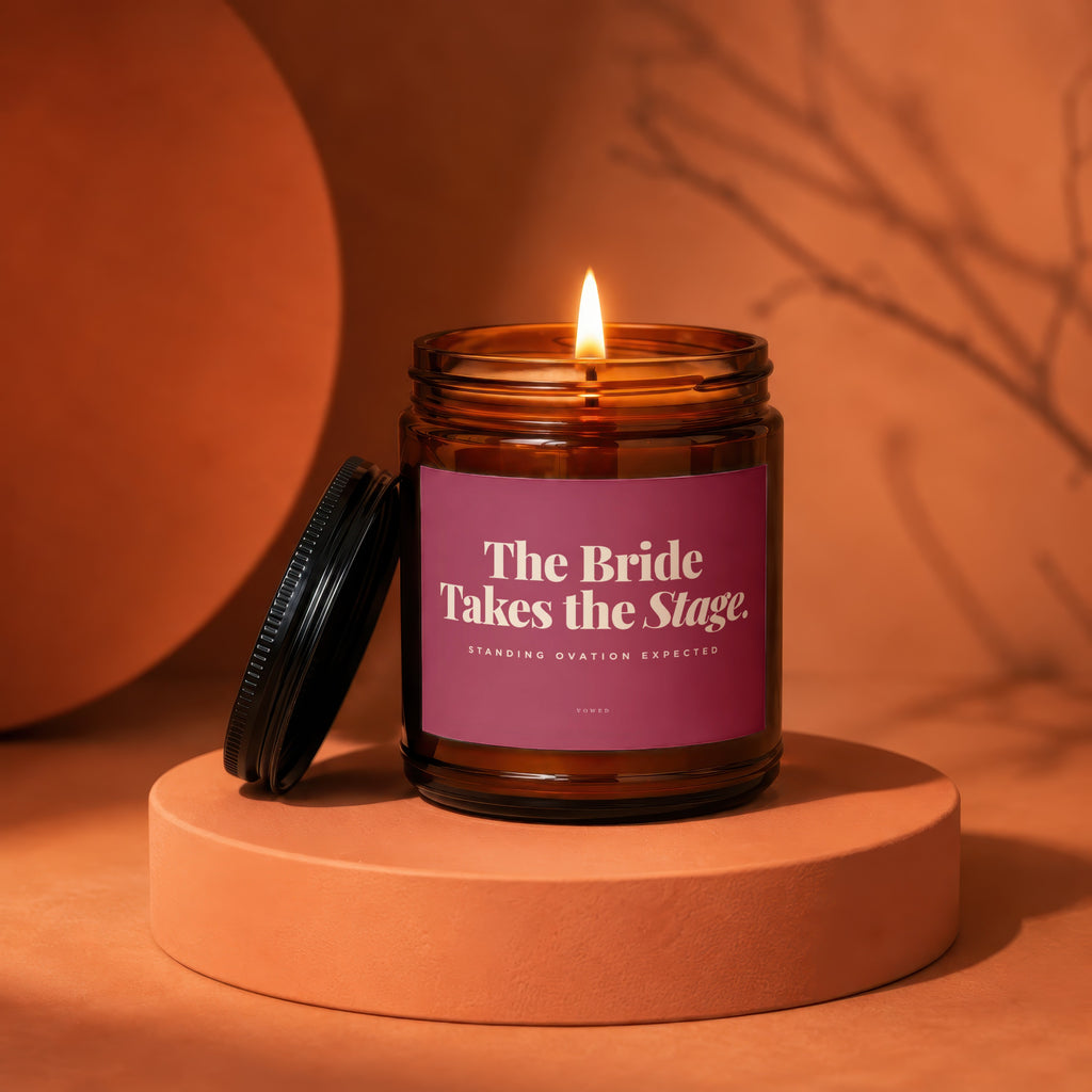 Amber jar candle with lit wick, reads "The Bride Takes the Stage."