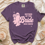 A purple crewneck t-shirt featuring a pink ghost holding flowers and the text Mother of the Bride Boo Crew.