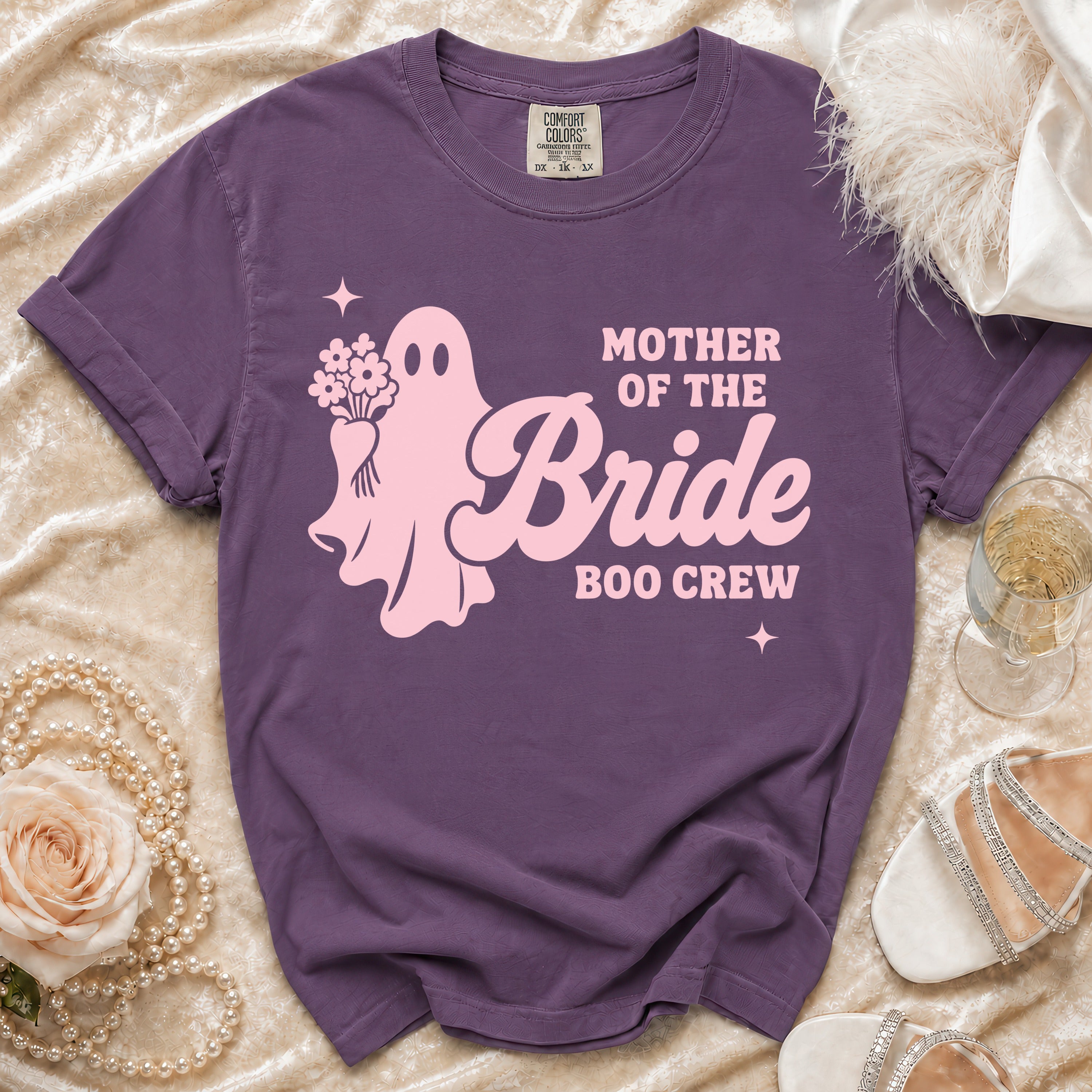 A purple crewneck t-shirt featuring a pink ghost holding flowers and the text Mother of the Bride Boo Crew.