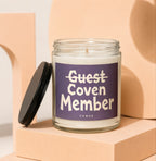 Glass candle with purple label reading "Guest Coven Member" and "vowed".