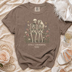 Skeleton couple on a bench surrounded by flowers, text "STILL CHOOSING YOU".