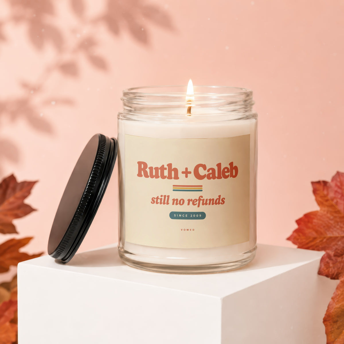 Glass candle labeled "Ruth + Caleb still no refunds SINCE 2009"