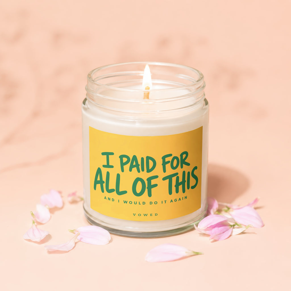 Glass jar candle, lit, with text "I PAID FOR ALL OF THIS AND I WOULD DO IT AGAIN VOWED".