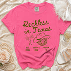 Pink t-shirt with "Reckless in Texas" and party graphics.