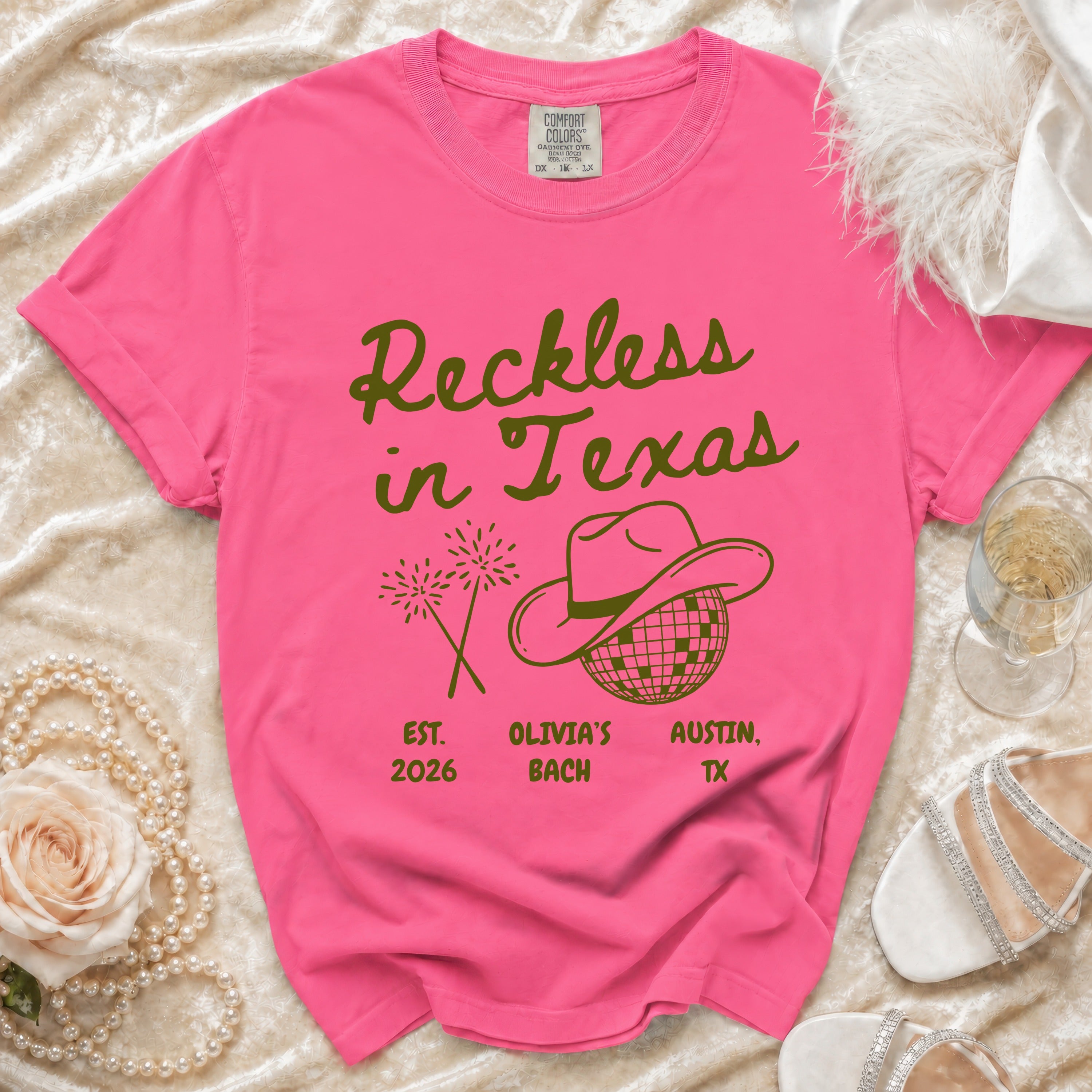 Pink t-shirt with "Reckless in Texas" and party graphics.