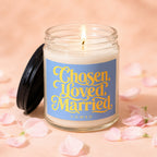 Lit candle with "Chosen, Loved, Married, Vowed" text on a blue label.