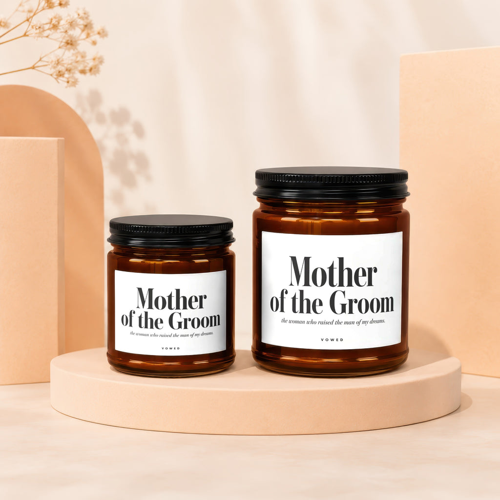 Two amber glass candles with white labels reading "Mother of the Groom".