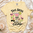 Yellow t-shirt with "This Bride Needs a Cosmo" graphic featuring drinks and makeup.