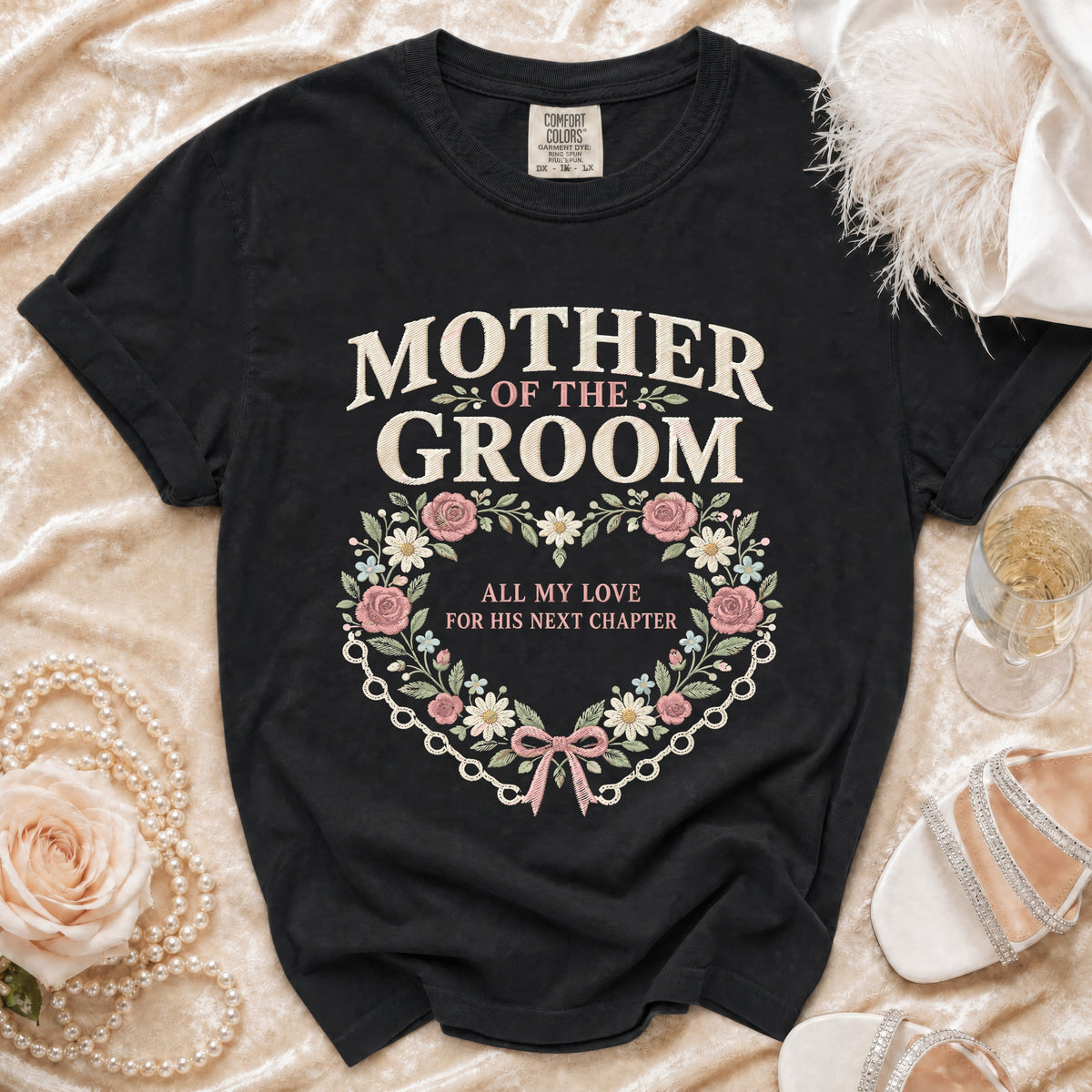 Black t-shirt with "Mother of the Groom" text and floral heart design.