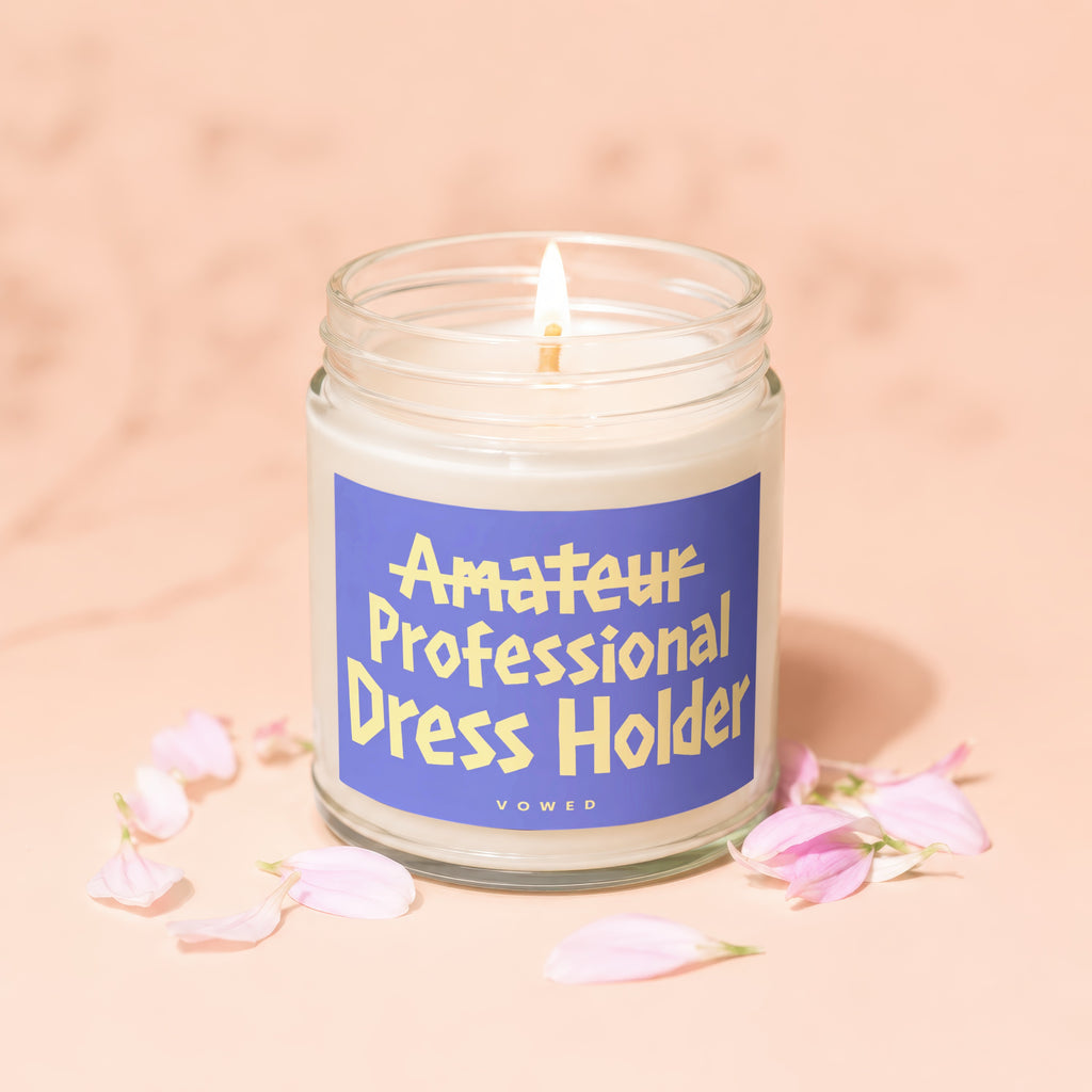 Candle with blue label reading "Amateur Professional Dress Holder Vowed".