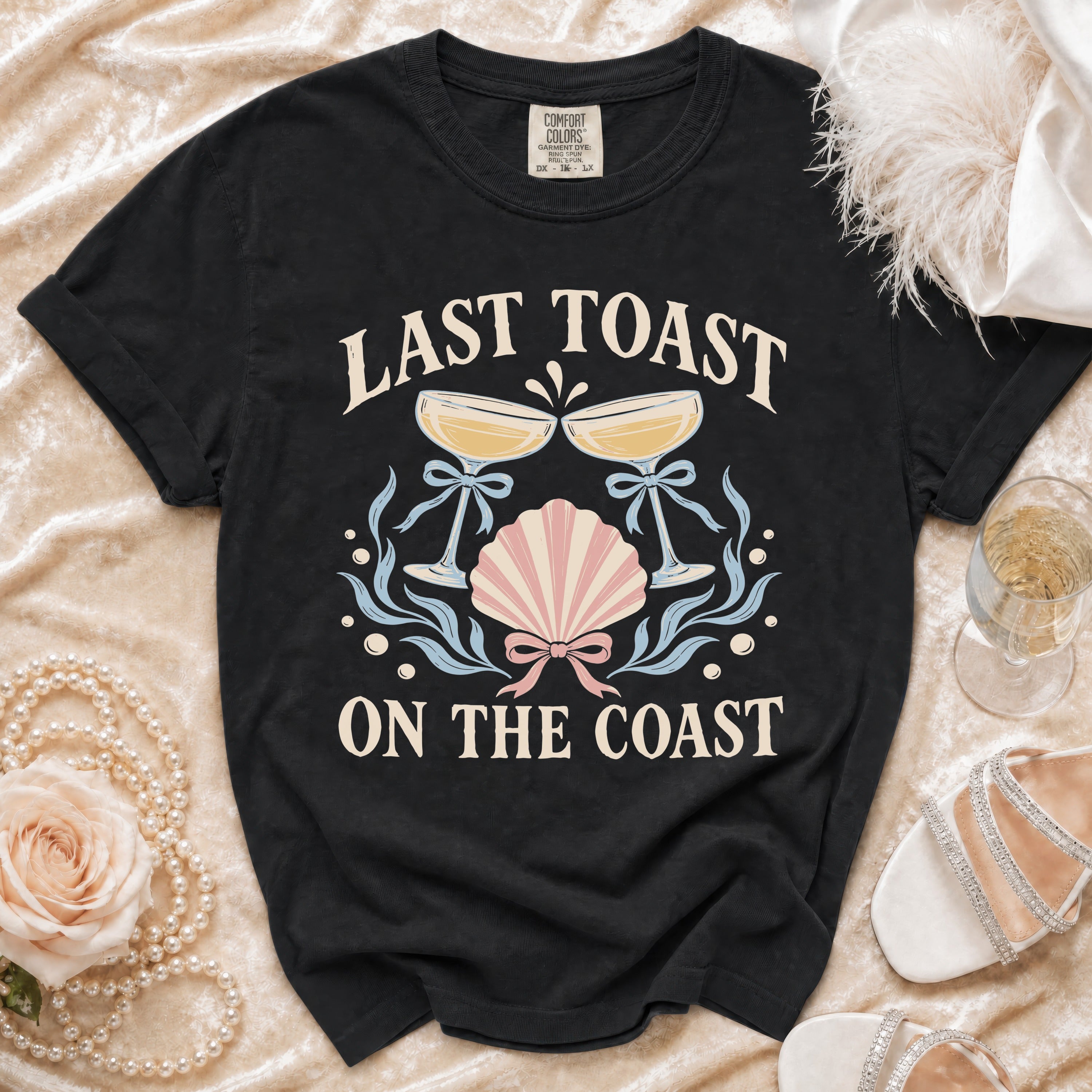 Black t-shirt with "Last Toast On The Coast" text and nautical graphics.