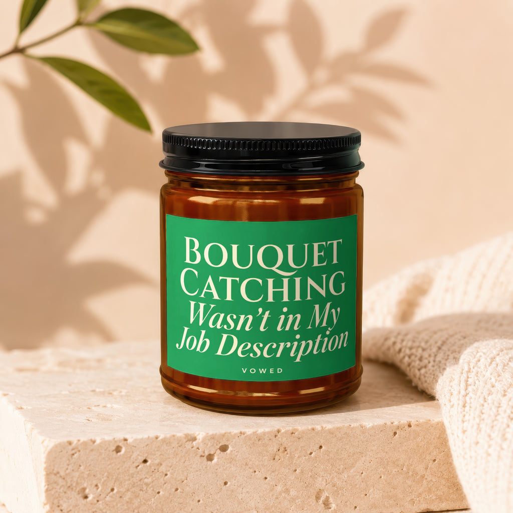 Glass jar candle with green label that reads "Bouquet Catching Wasn't in My Job Description Vowed."