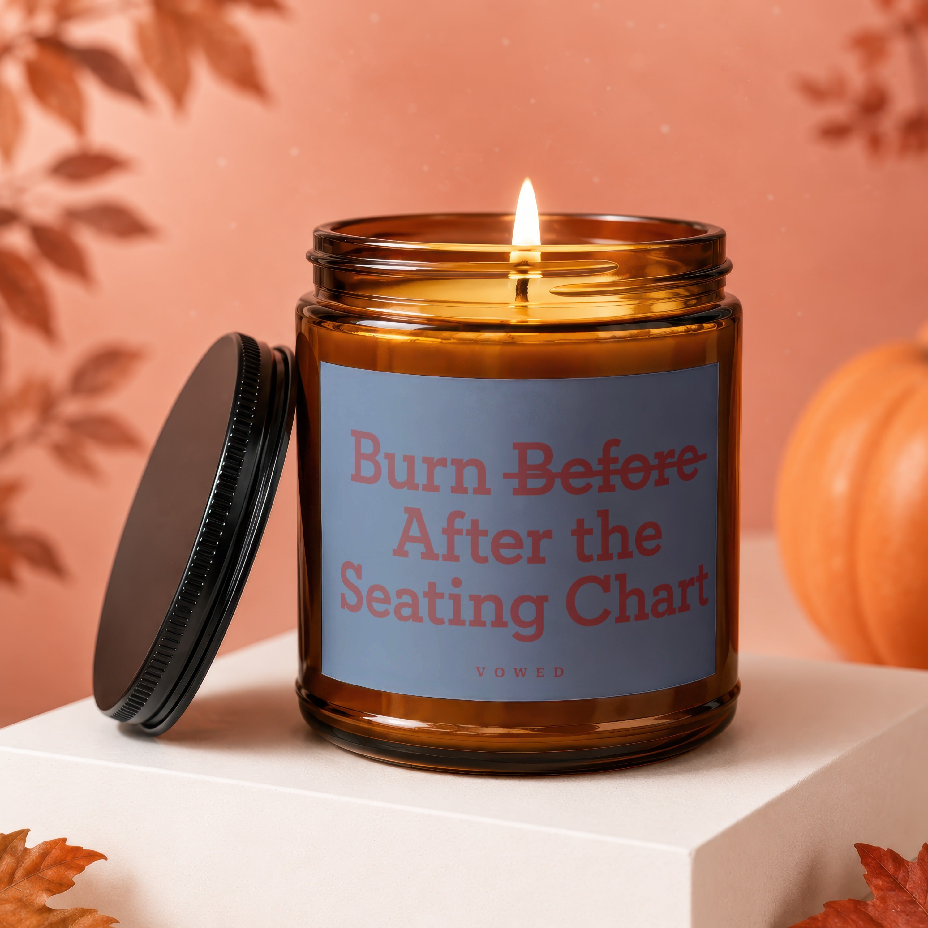 Amber jar candle with lit flame and text "Burn Before After the Seating Chart"