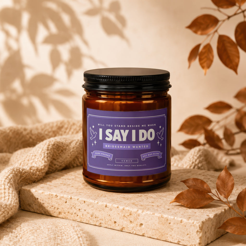Amber jar candle with "I Say I Do Bridesmaid Wanted" label, surrounded by neutral textures.