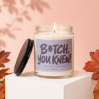 Glass candle with "B*tch, You Knew!" text and lid nearby.