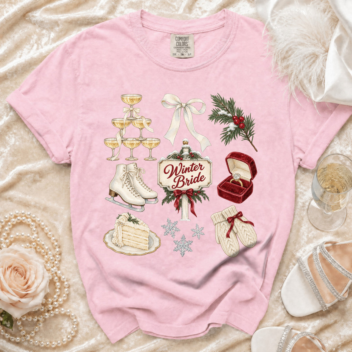 Pink t-shirt with Winter Bride graphic including champagne tower, ice skates, and ring.
