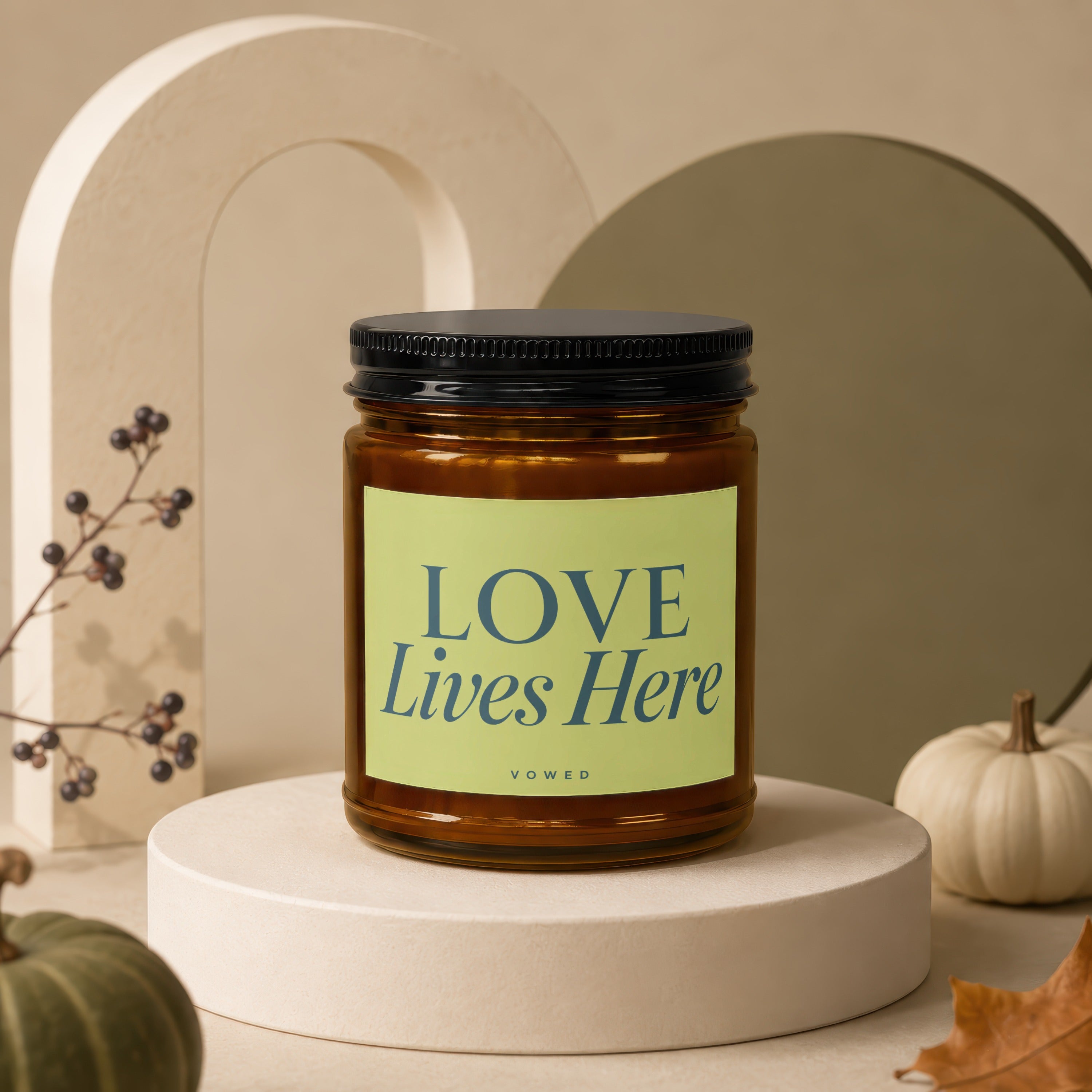 Amber candle in a glass jar with green label reading "LOVE Lives Here"
