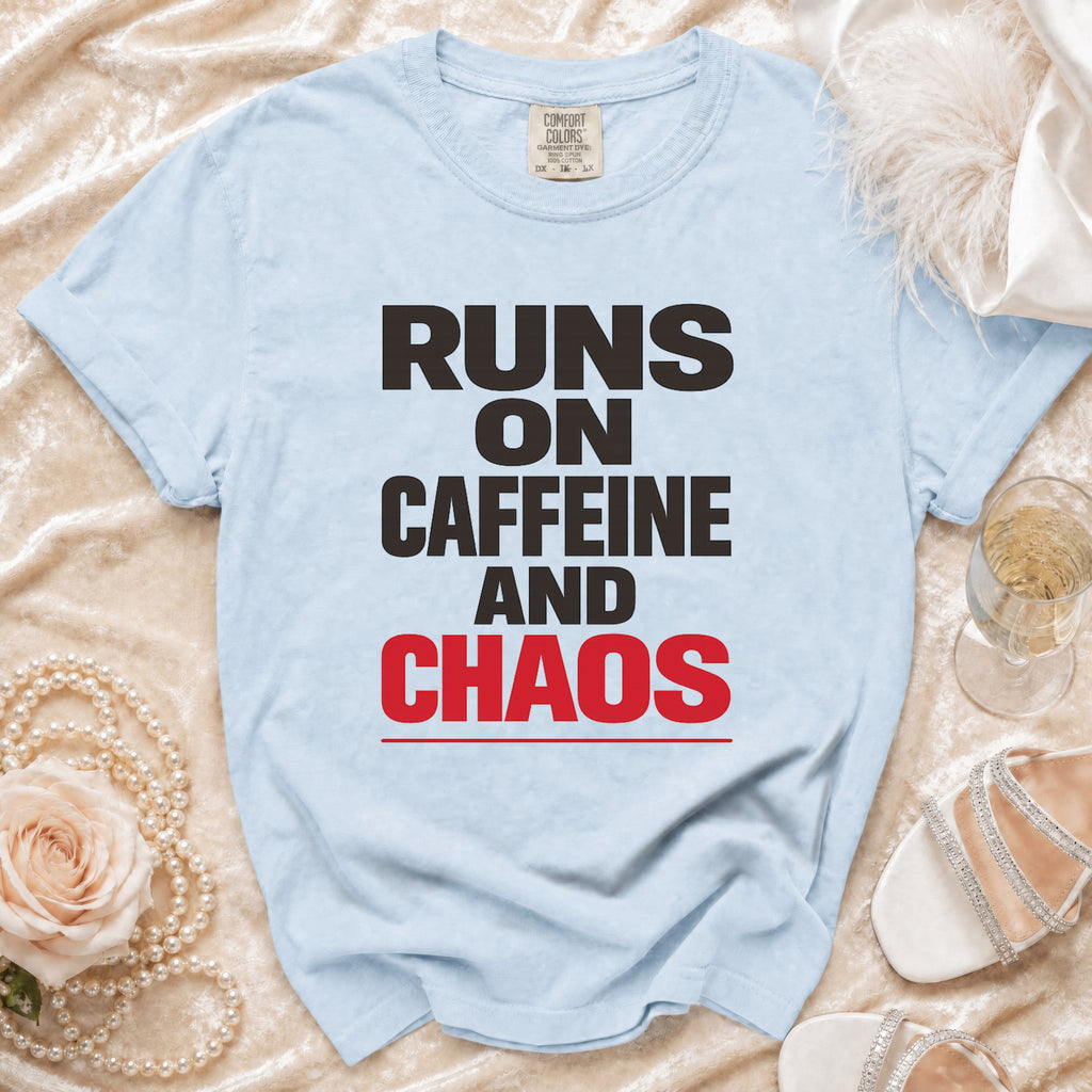 Light blue t-shirt with black and red text reading "RUNS ON CAFFEINE AND CHAOS".