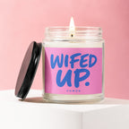 Glass candle with a lit wick, labeled "WIFED UP. VOWED" on a pink background.